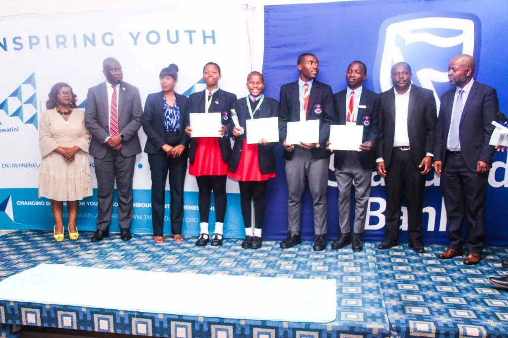 Vulamasango students holding certificates beside guests at the JA Eswatini awards